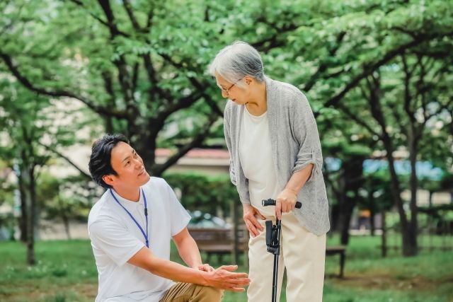 介護士にサポートを受ける高齢女性.jpg